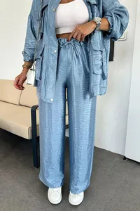 Completo due pezzi azzurro cangiante composto da giacca utility e pantaloni a gamba dritta.