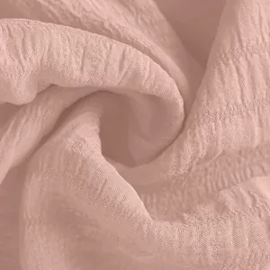 Macro view of soft pink crinkle fabric texture detail for women's summer sports shorts