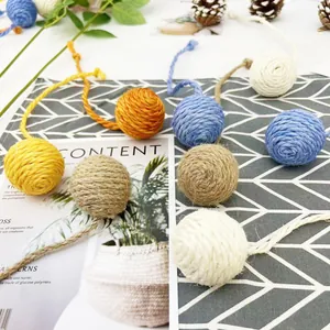 Vista detallada de pelotas de sisal de colores para gatos con colas largas de cuerda