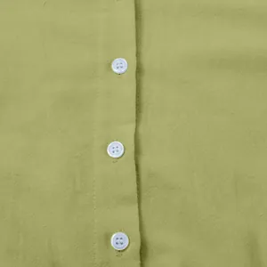 Close-up detail of the white buttons and natural linen fabric texture of a green casual dress
