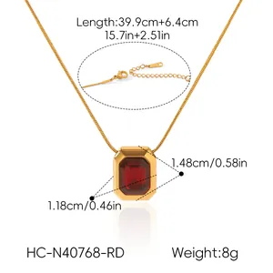 Dettaglio di una collana in acciaio inossidabile dorato con pendente rettangolare rosso
