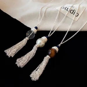 Elegante collana con nappa in perle e vetro con catena argentata su uno sfondo nero
