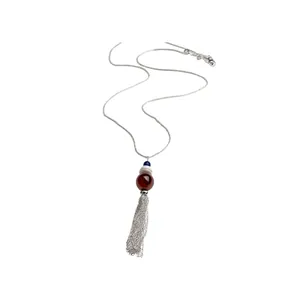 Elegante collana con nappa d'argento e una perla di vetro marrone su sfondo bianco.