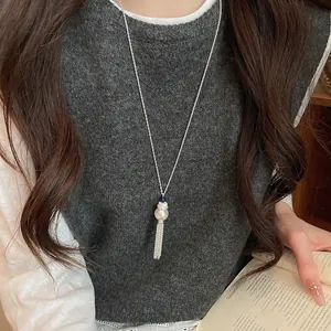 Dettaglio di una collana lunga per maglioni con perla e nappa in stile coreano chic