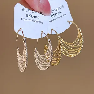 Primo piano di orecchini pendenti ovali vintage in argento e oro su cartellini espositivi