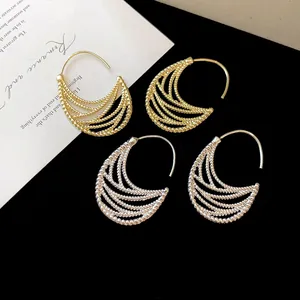 Primo piano di orecchini a cerchio in metallo multi-filo in finitura oro e argento