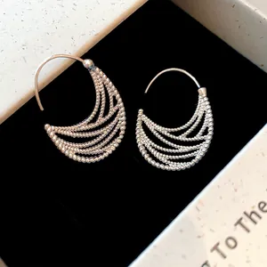 Dettaglio orecchini vintage in argento traforati con elegante trama a microsfere