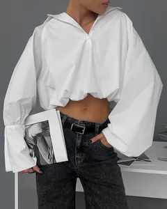 Detailansicht eines weißen kurzen Polohemds mit Puffärmeln und drapiertem Design