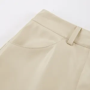 Detailansicht von Taille, Gürtelschlaufe und Tasche eines beigen Kunstlederrocks