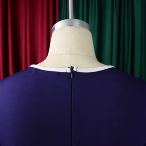 Detailed view of the invisible back zipper and white contrast piping on a navy blue dress.