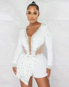 Elegante tutina bianca a maniche lunghe con pannelli in rete velata e strass di perle