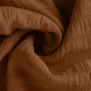 Detailed macro shot showing the premium brown crinkled fabric texture for summer shorts