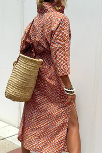Detail view of women's orange patterned shirt dress with half sleeves and side slit