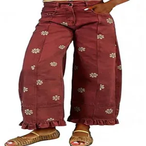 Close-up detail of Y2K vintage wine red wide leg jeans with floral print and ruffle hem