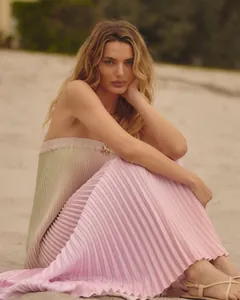 Détail d'une robe bustier plissée dégradée chic portée sur une plage ensoleillée