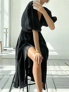 Detailed view of a chic black slit dress with puff sleeves and tie waist detail