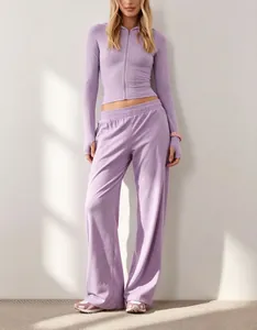 Vista completa di felpa con cappuccio viola e pantaloni a gamba larga coordinati casual