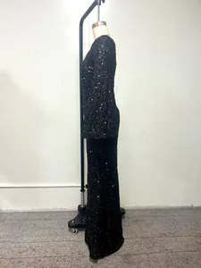 Side view of a black sequin evening gown with flare sleeves and floor-length hem