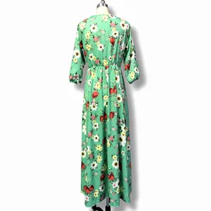 Back view of a green bohemian floral maxi dress with vibrant prints on a mannequin