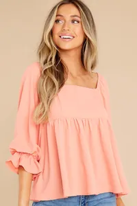 Close-up of elegant coral square neck top with ruffled sleeve details for women.