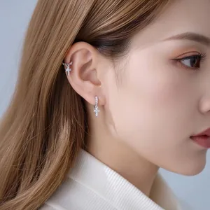 Elegant silver-toned cross dangling earrings with micro-pave zircons shown on an Asian model