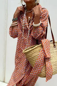 Detail of orange geometric print shirt dress with straw bag and matching scarf.