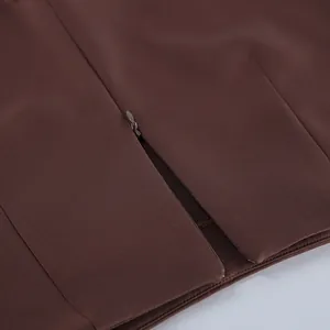 Nahaufnahme des verdeckten Reißverschlusses und des braunen Strukturstoffs der Hose.