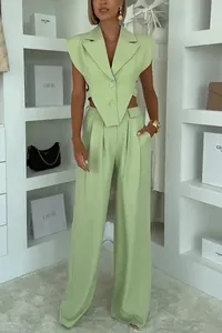 Detailed view of fashionable mint green sleeveless vest and high waist wide-leg trousers set