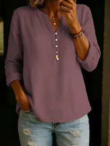 Detailed view of mauve cotton linen V-neck top with white button accents and texture