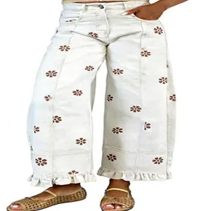 Detail of white floral print wide-leg jeans with vintage Y2K ruffled hem design.
