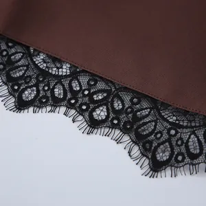 Detailaufnahme von schwarzer Wimpernspitze am braunen Stoff einer weiten Shorts.