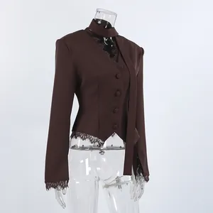 Elegante bruine damesblazer met kanten details aan de zoom en manchetten op een pop