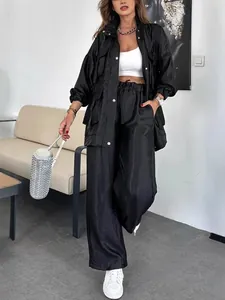 Elegante completo due pezzi nero da donna con giacca a tasche e pantaloni larghi