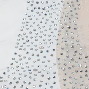 Dettaglio macro di strass luccicanti su tessuto bianco e a rete di un body sexy