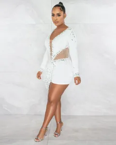 Dettaglio ravvicinato della tuta sexy in rete bianca con strass brillanti e perle fini.