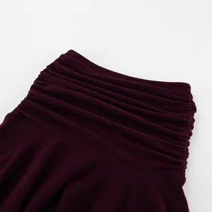 Dettaglio di elegante gonna in maglia bordeaux a vita alta con dettagli a pieghe