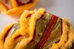 Macro detail of Chinese dog lion dance costume with gold sequins and yellow faux fur