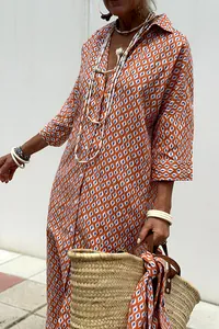 Detail of a bohemian orange and blue geometric pattern long shirt dress with collar.