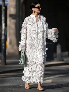 Détail de la dentelle blanche ajourée et des appliques florales 3D sur la robe maxi