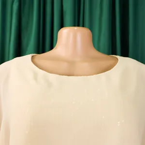 Detailansicht eines cremefarbenen Abendkleids aus Chiffon mit dezenten Pailletten am Ausschnitt