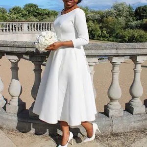 Detail eines eleganten weißen Abendkleids mit weitem Rock und 3/4-Ärmeln im Freien