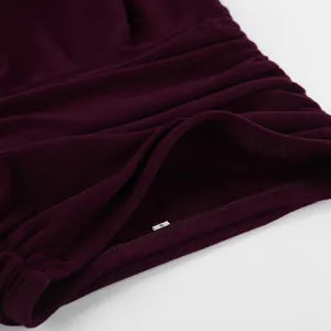 Primo piano della trama drappeggiata elegante e delle coutures di una gonna in maglia bordeaux