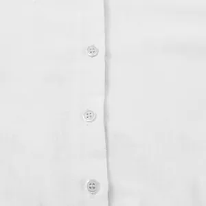 Macro detail of white cotton linen fabric and translucent buttons on casual dress