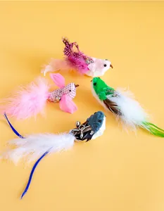 Primo piano di quattro giocattoli per gatti a forma di uccello con piume e piccoli campanelli.