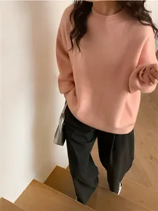 Gros plan détaillé d'un pull en maille pêche ample pour femme de style vintage
