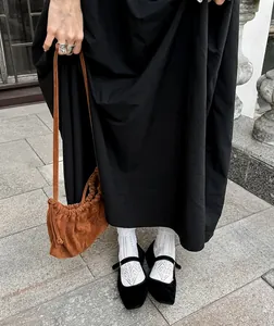Detail shot of a vintage Hepburn style black dress paired with stylish accessories