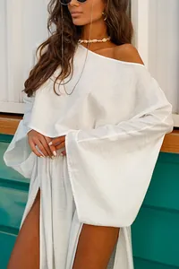 Elegant white two-piece set with loose long-sleeved top and high-slit skirt detail