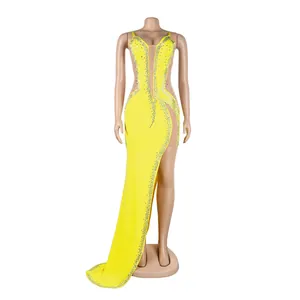 Detail view of the yellow evening gown's asymmetrical high slit and rhinestone patterns.