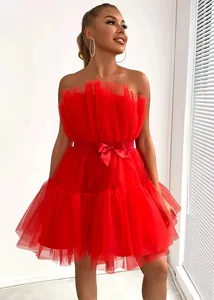 Elegant red strapless tulle dress featuring a waist bow and tiered puffy skirt.