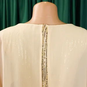 Detailansicht eines Chiffon-Partykleides mit goldenen Pailletten und Reißverschluss.